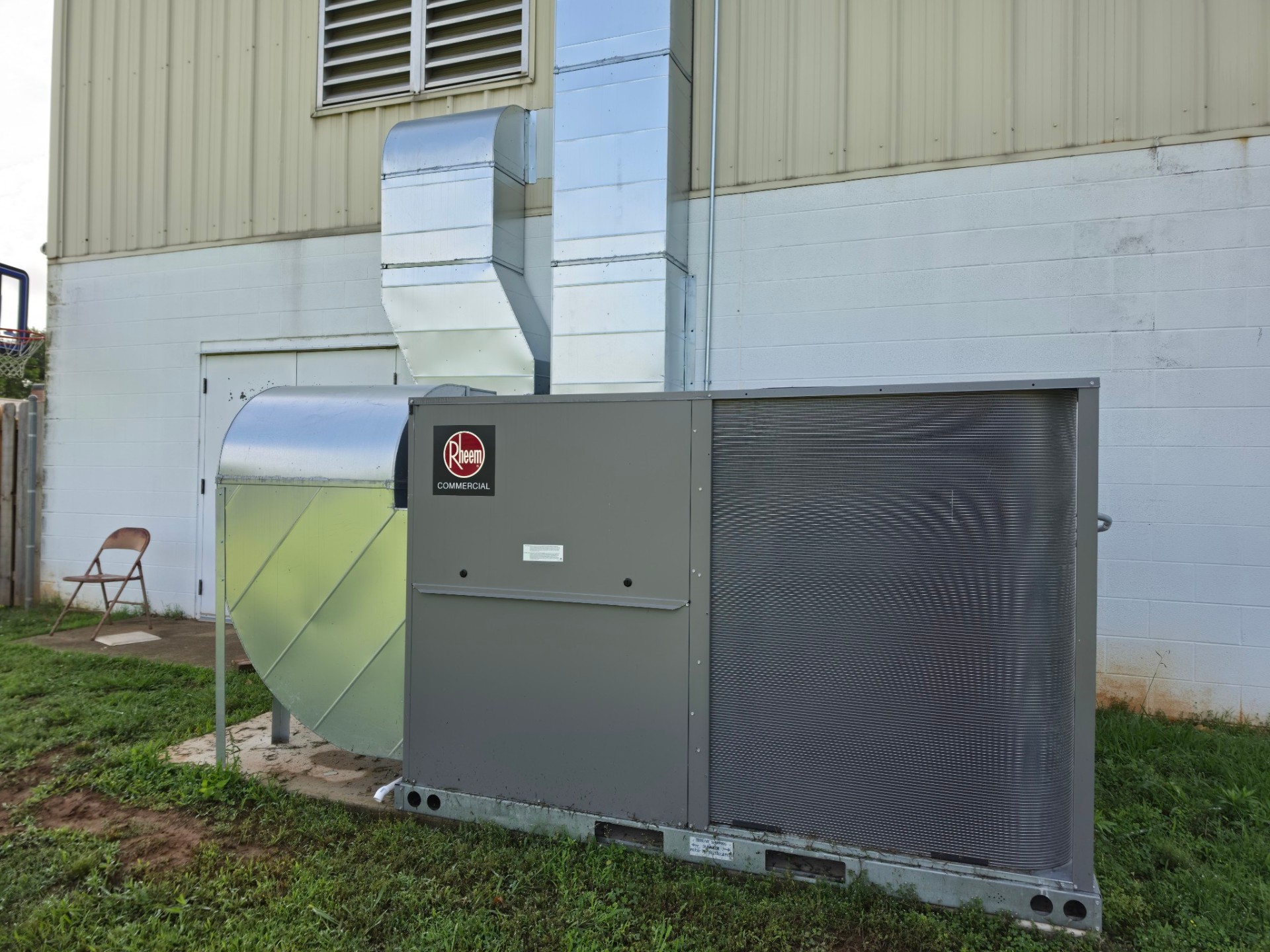 Commercial Rheem rooftop HVAC unit installed beside a building